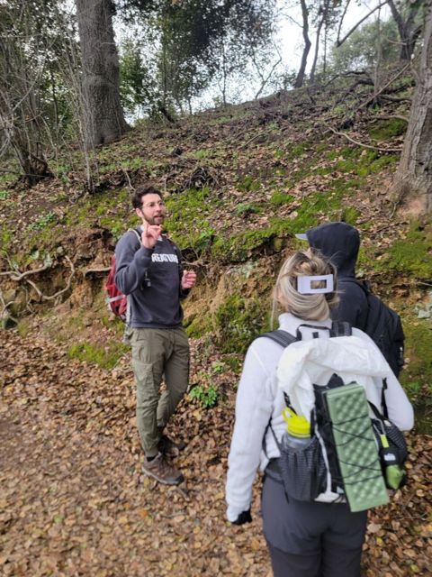 Nick Robertson teaching two hikers about mushrooms on a trail